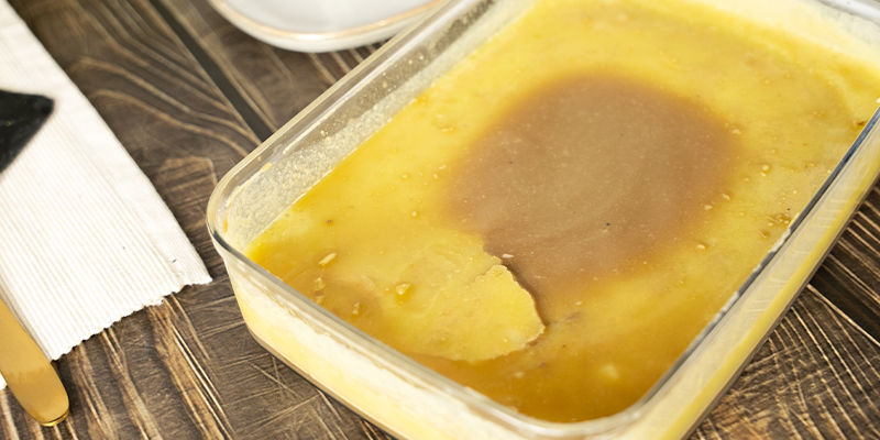 Nästa dag tar du försiktigt upp lagret med cannasmör ur behållaren. When you come back the next day, carefully remove the layer of cannabutter from the container.