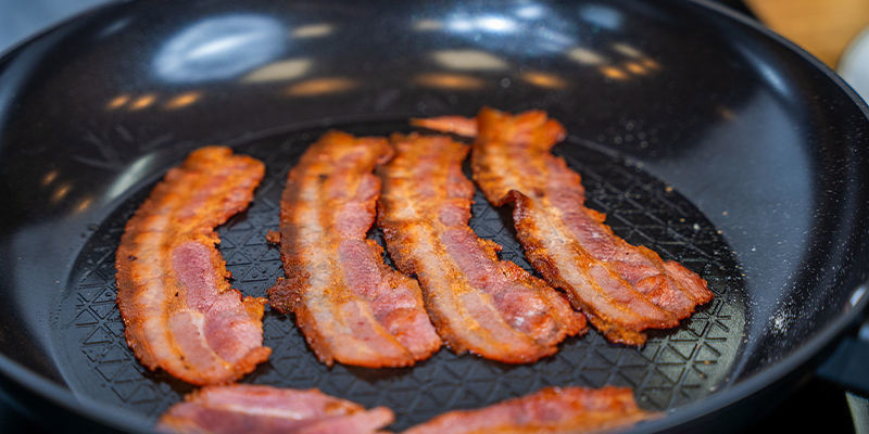 Stek baconet i en stekpanna på medelvärme Fry The Back Bacon In The Frying Pan On A Medium Heat