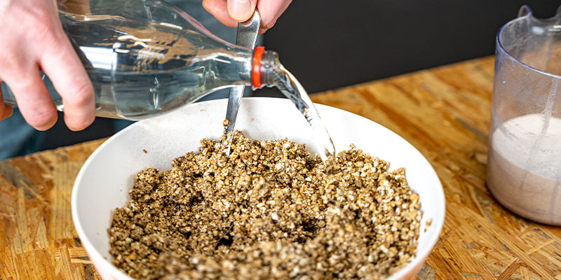 Häll vatten över vermikuliten så att den blir fuktig PF tek Pour water over the vermiculite to wet it