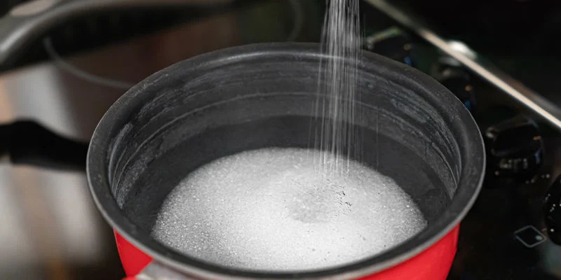 Blanda vatten och socker i en kastrull och värm på medelvärme tills sockret har löst sig helt. Combine the water and sugar in a saucepan and heat at a medium temperature until the sugar dissolves completely.